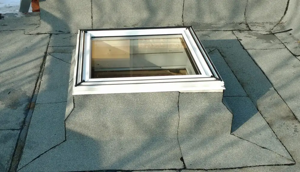 Skylight flashed into a flat roof membrane